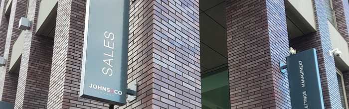 Projecting sales sign on a brick office building
